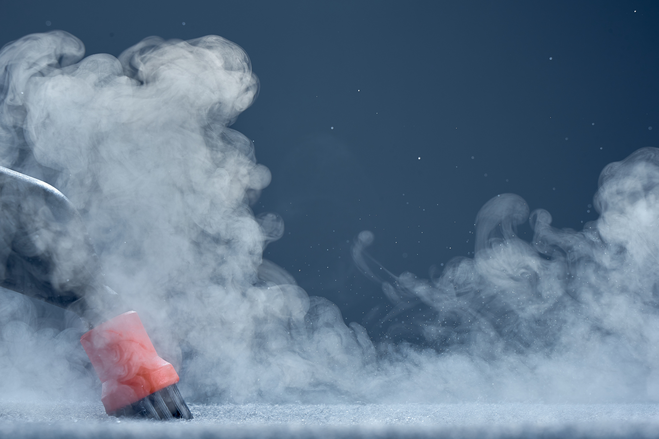 Steam close-up. Steam carpet cleaning on blue background. Home cleaning. Photo with copy space.